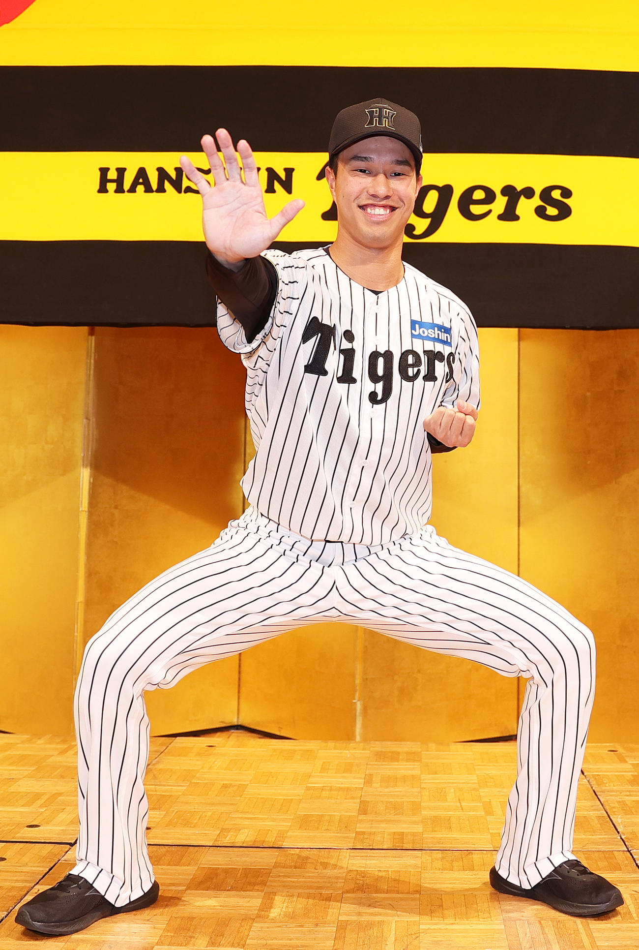 阪神新人入団会見でポーズをとるドラフト3位の岡城（撮影・上山淳一）