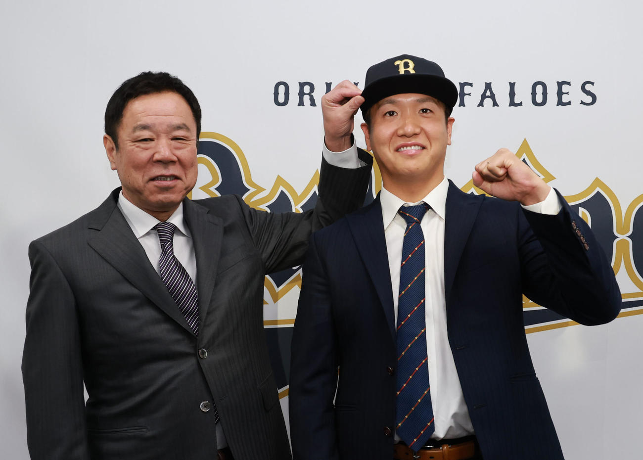 福良GM（左）から帽子をかぶせられ笑顔を見せる平沼（撮影・上田博志）