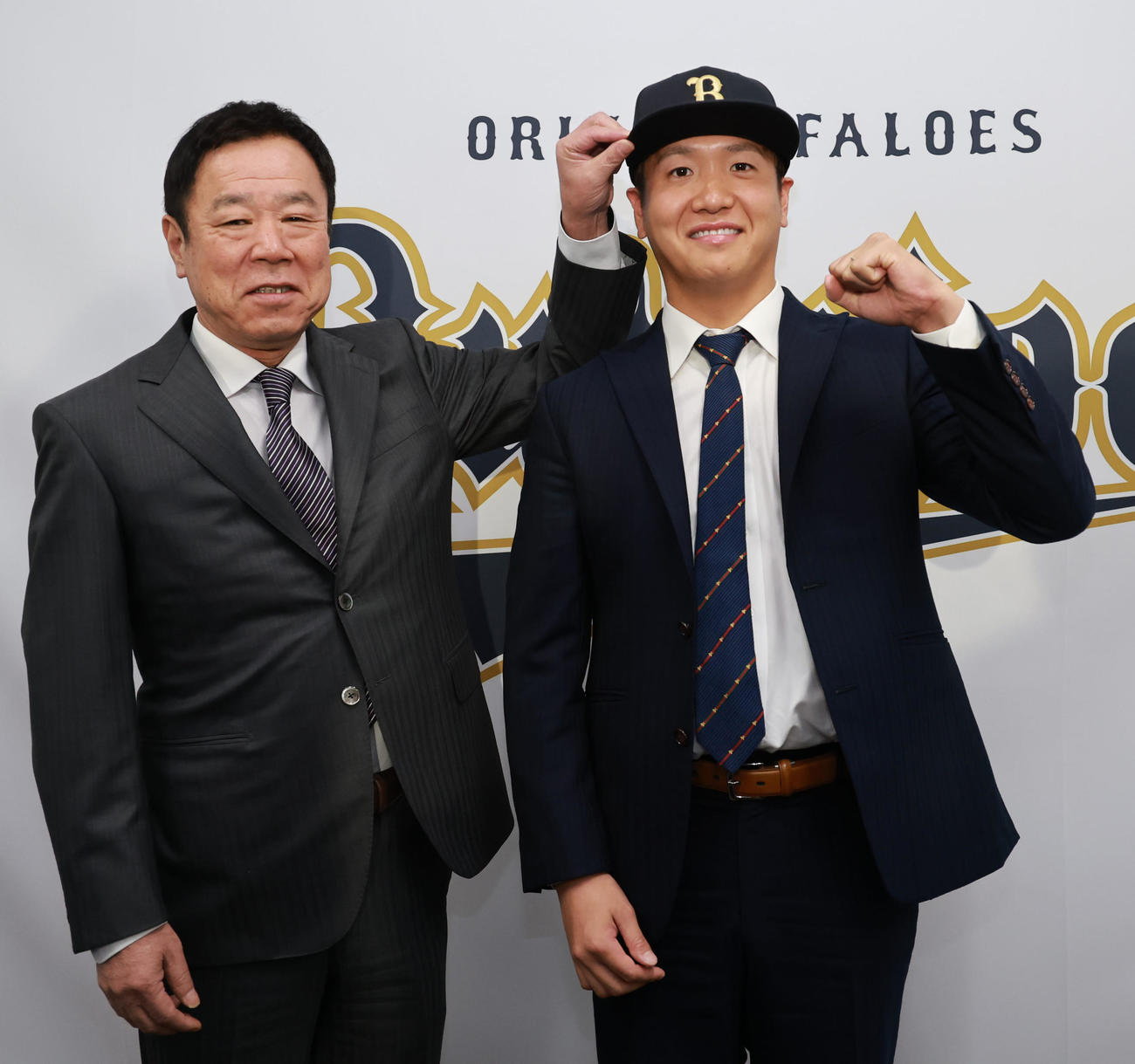 福良GM（左）から帽子をかぶせられ笑顔を見せる平沼（撮影・上田博志）