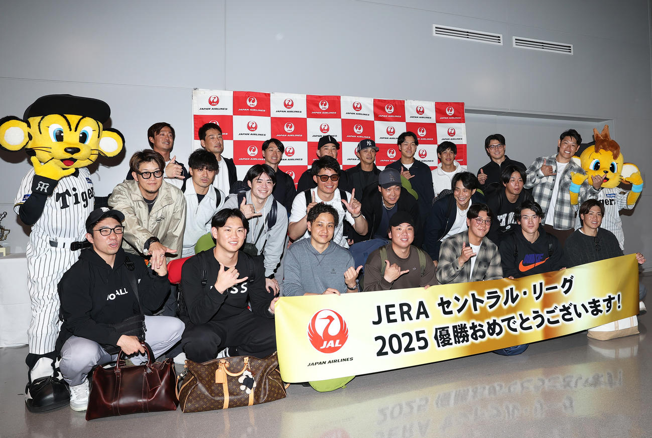 優勝旅行出発を前にアロハポーズを決め記念撮影する阪神の選手ら（撮影・上山淳一）