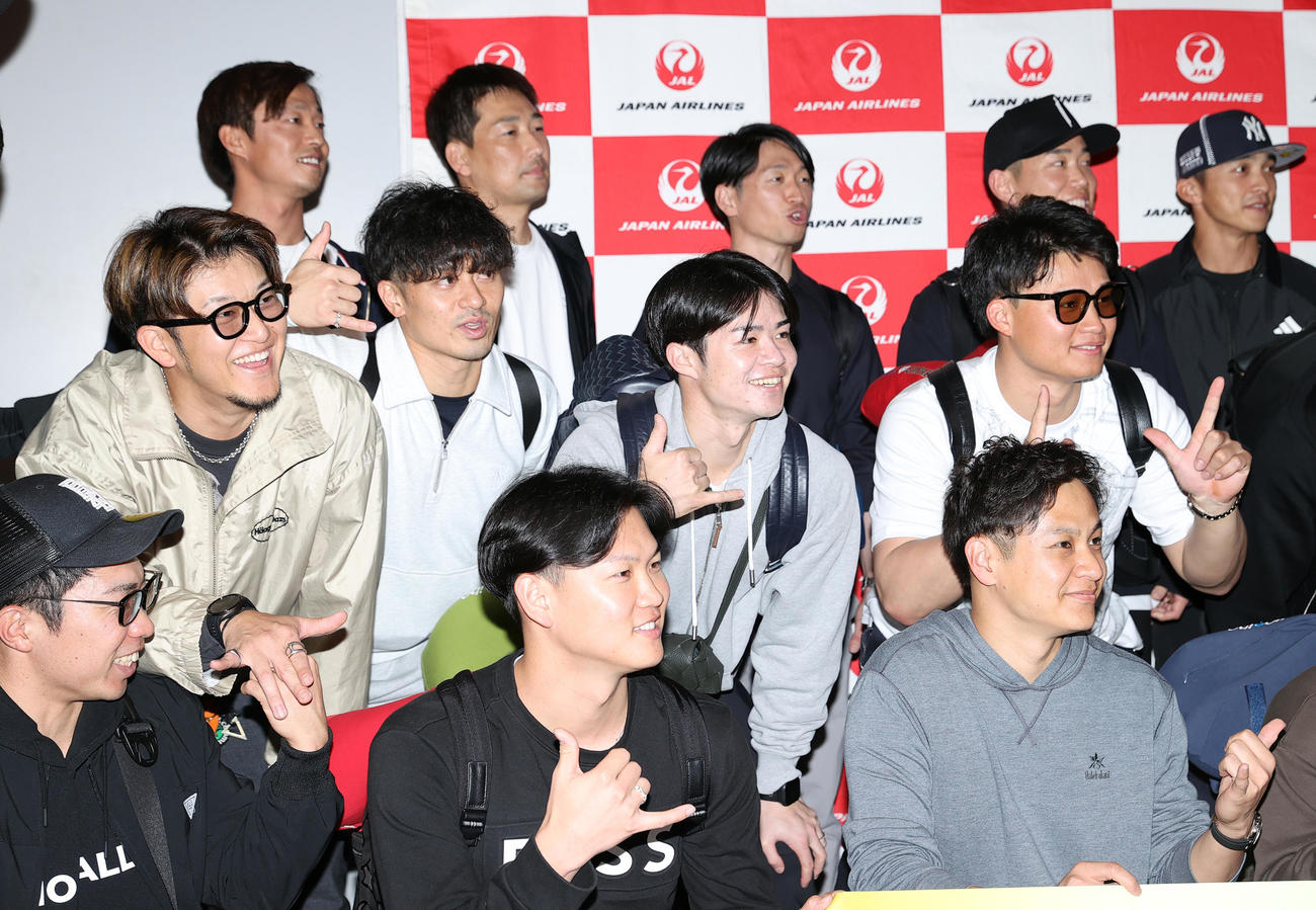 優勝旅行出発を前にアロハポーズを決め記念撮影する阪神の選手ら、前列左から石井、及川、大竹、中列左から岩貞、坂本、中野、森下、後列左から島本、岩崎、近本、糸原、熊谷（撮影・上山淳一）