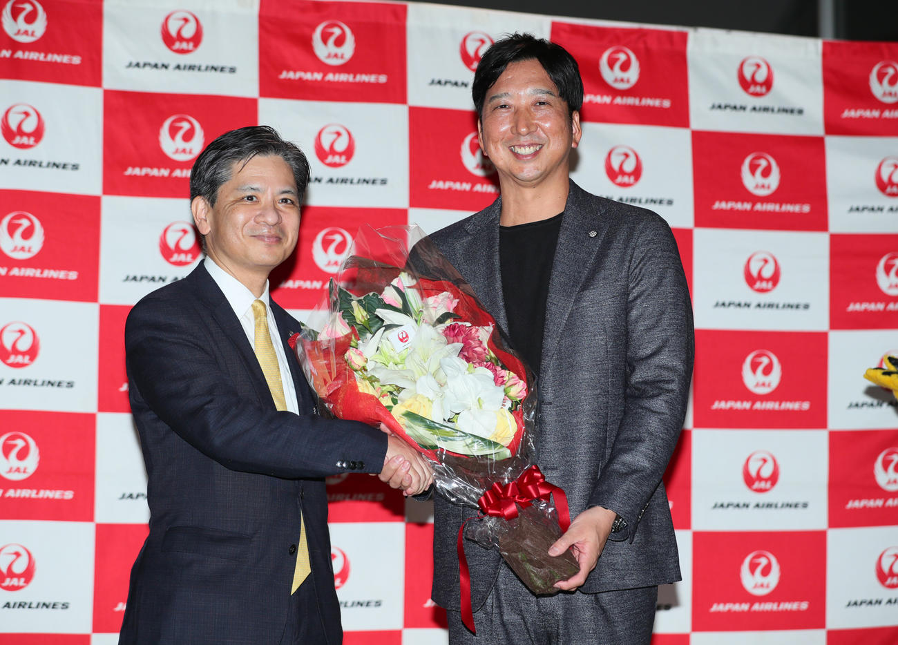 阪神優勝旅行出発セレモニーで藤川監督（右）は日本航空・越智常務執行役員から花束を受け取る（撮影・上山淳一）