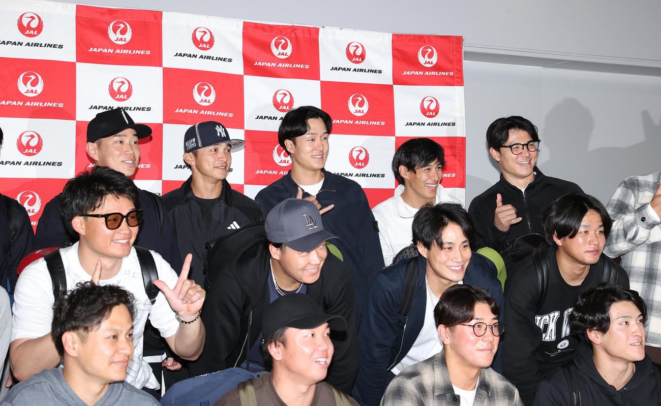 優勝旅行出発を前にアロハポーズを決め記念撮影する阪神の選手ら、前列左から大竹、村上、豊田、高寺、中列左から森下、大山、木浪、高橋、後列左から糸原、熊谷、小幡、植田、栄枝（撮影・上山淳一）