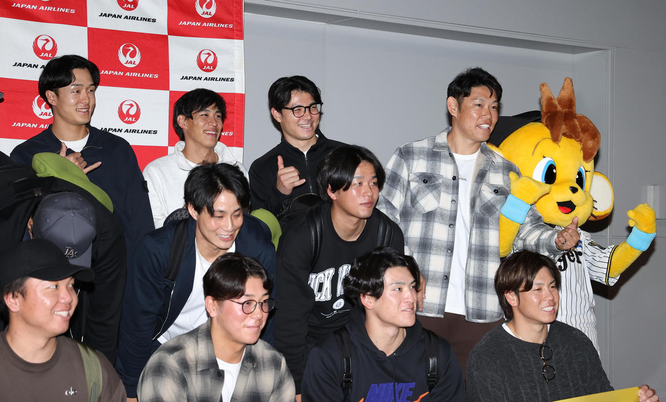 優勝旅行出発を前にアロハポーズを決め記念撮影する阪神の選手ら、前列左から村上、豊田、高寺、梅野、中列左から木浪、高橋、後列左から小幡、植田、栄枝、原口（撮影・上山淳一）