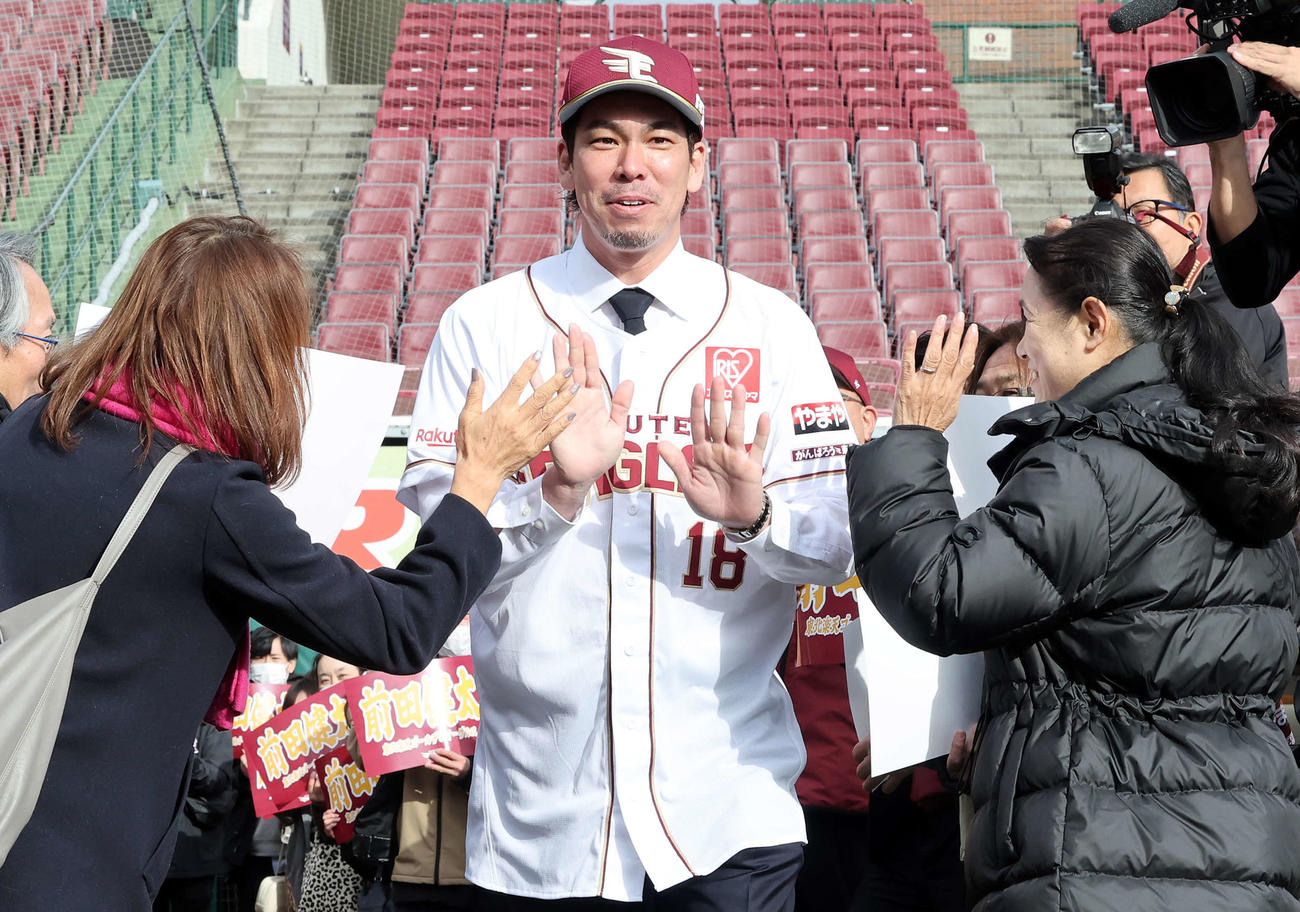 楽天入団会見で、ファンとハイタッチしながらグラウンドに出る前田健（撮影・浅見桂子）