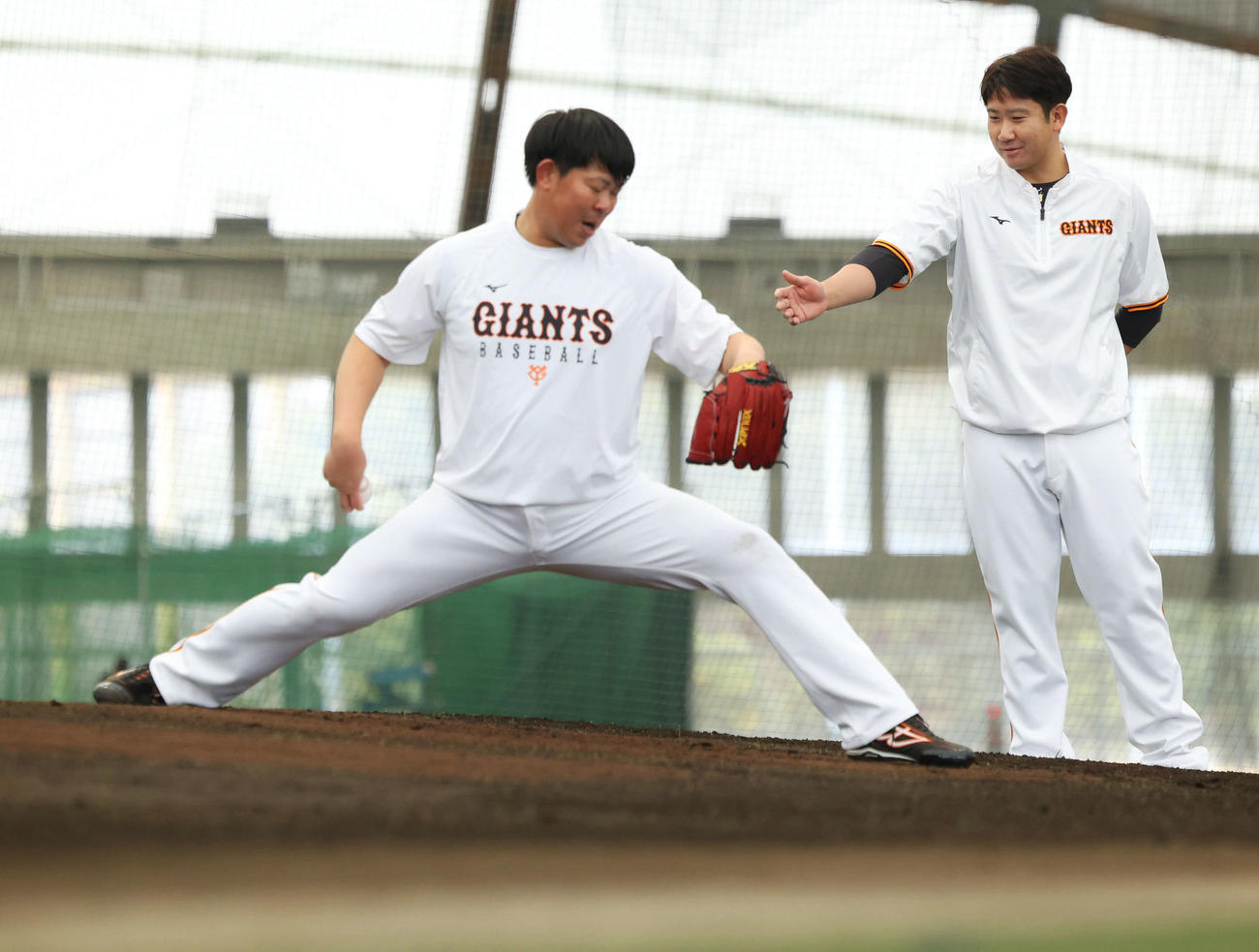 ブルペン投球する巨人山口（左）にアドバイスする菅野（2022年2月2日撮影）