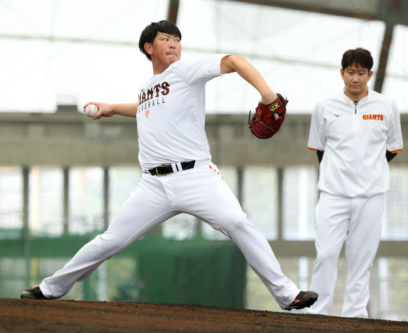 ブルペン投球する巨人山口（左）を見る菅野（2022年2月2日撮影）