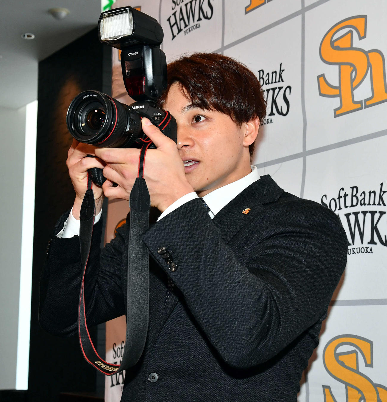 契約更改したソフトバンク谷川原は昇給分で「子どもを撮影するカメラを購入したい」とし、報道陣からカメラを借りて構える（撮影・岩下翔太）