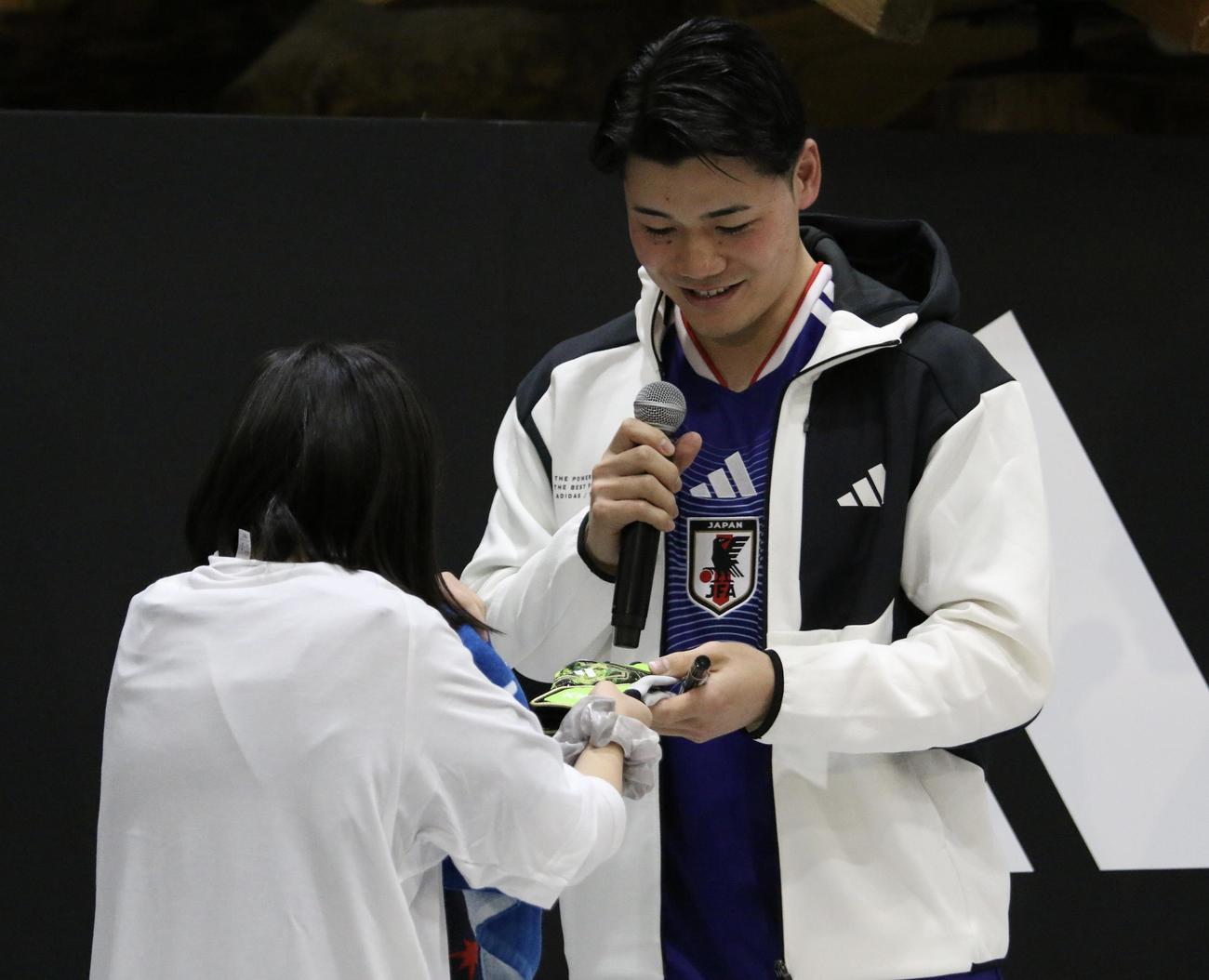 札幌市内でのトークショーで、抽選番号「21番」を持っていた女の子にサプライズで革手袋をプレゼントする日本ハム清宮幸＝2025年12月19日