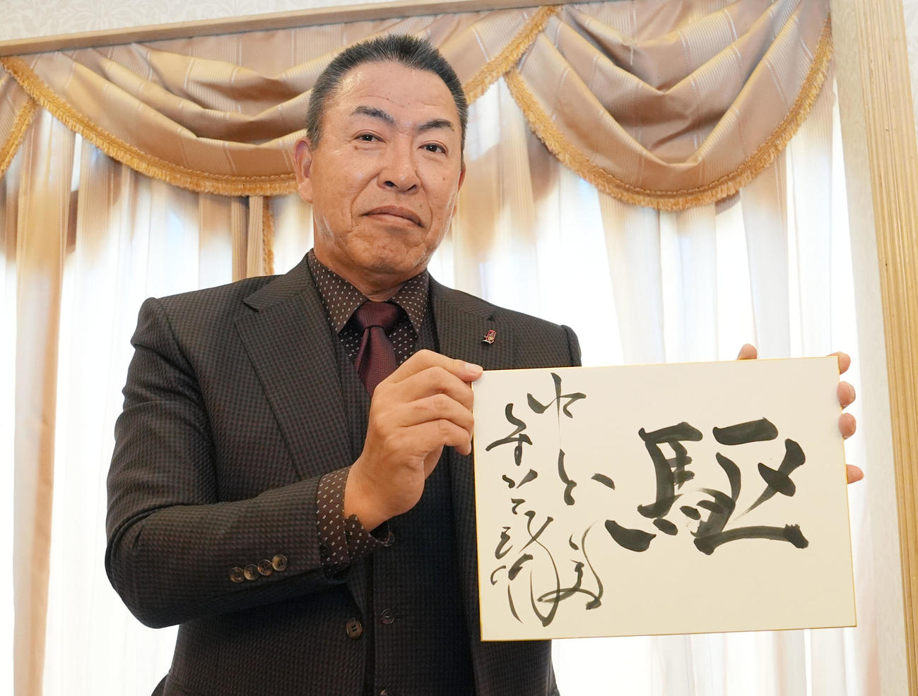 2026年シーズンのイメージを漢字1文字で「駆」と色紙に記した井上一樹監督（撮影・森本幸一）