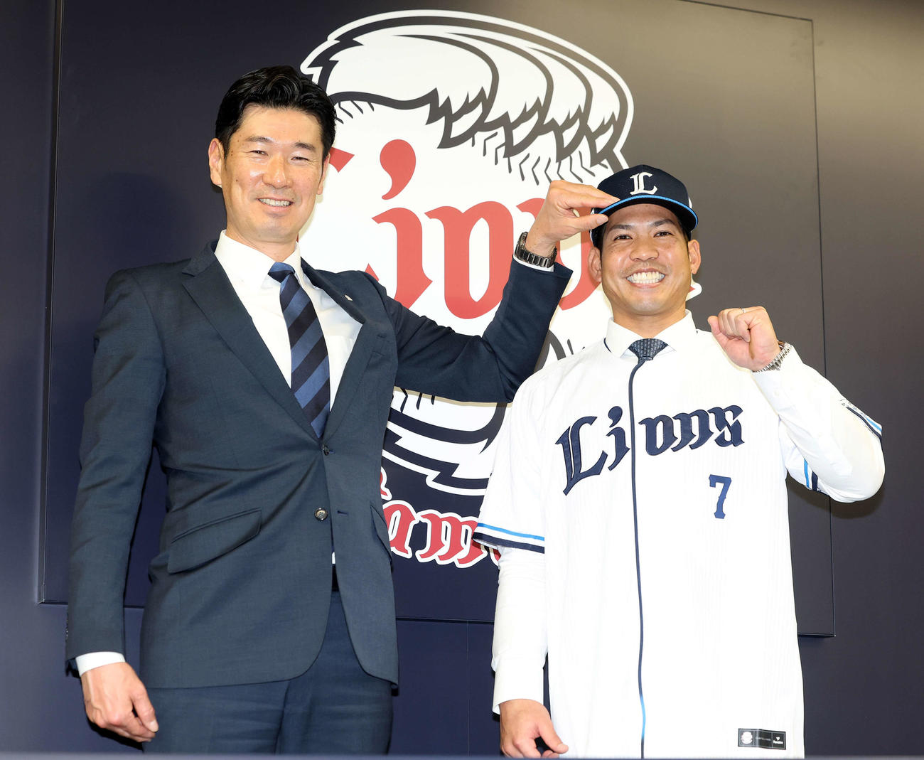西武入団会見で広池球団本部長（左）に帽子をかぶせてもらい笑顔の桑原（撮影・浅見桂子）