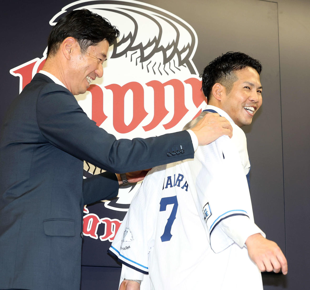 西武入団会見で広池球団本部長からユニホームを着せてもらう桑原（右）（撮影・浅見桂子）