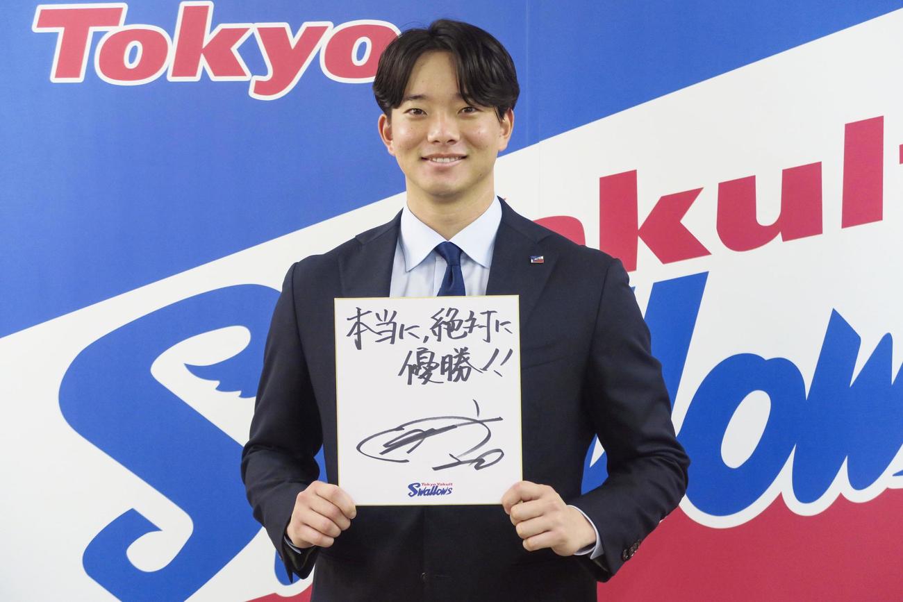 契約更改を終え、来季の目標を書いた色紙を手にするヤクルト木沢（共同）