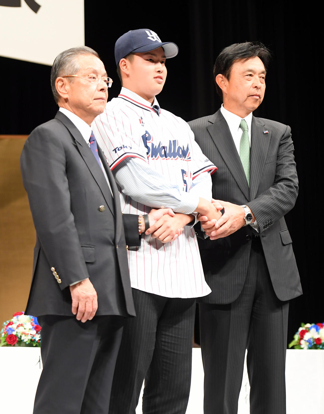 17年12月、ヤクルト新入団発表会見で笑顔を見せるラフト1位の村上（中央）。左は衣笠社長、右は小川監督