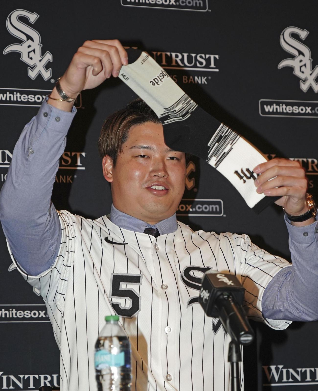 ホワイトソックスの入団記者会見で靴下を掲げる村上（共同）