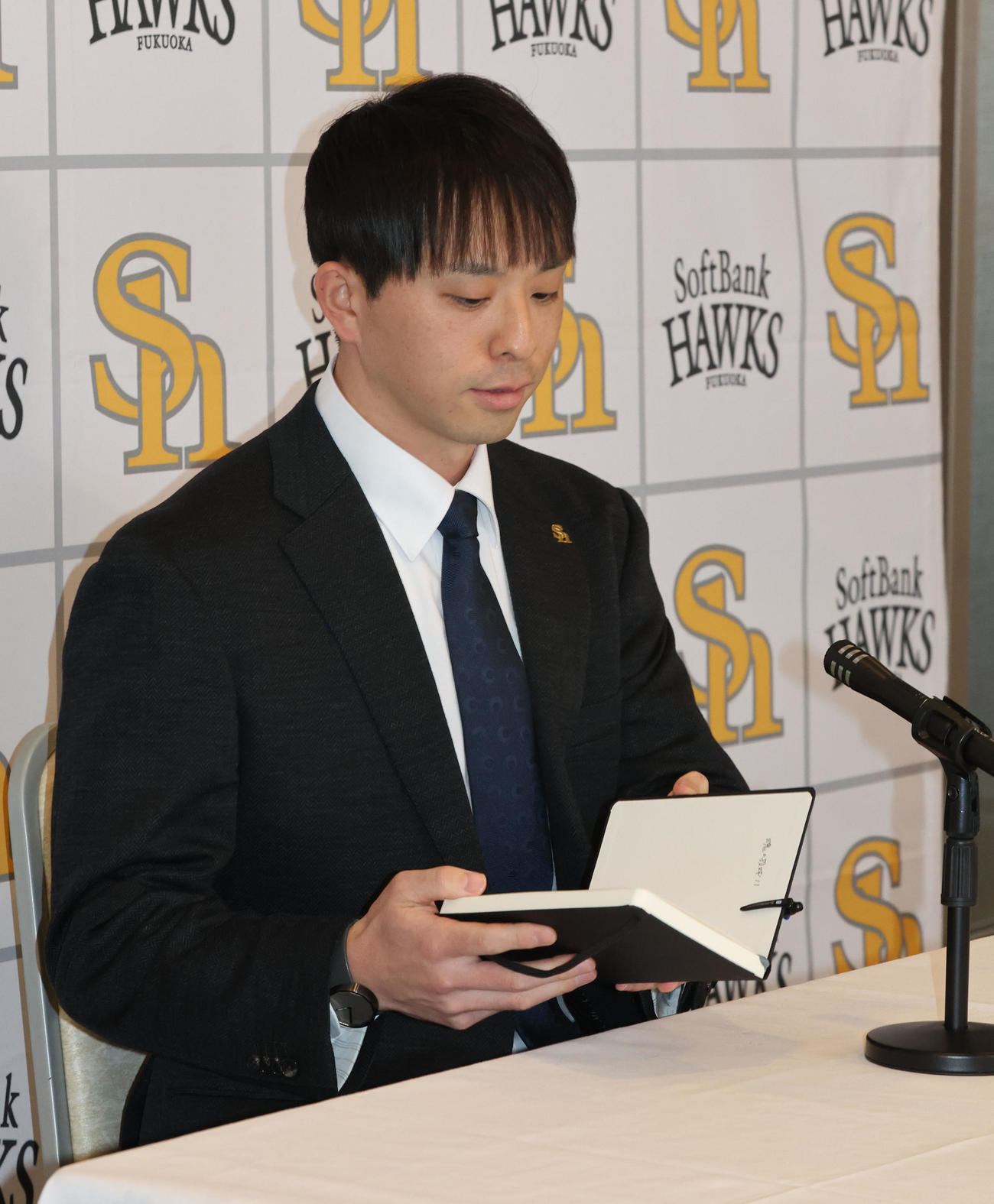契約更改を終えたソフトバンク大関は手帳を手に会見の席に着く（撮影・梅根麻紀）