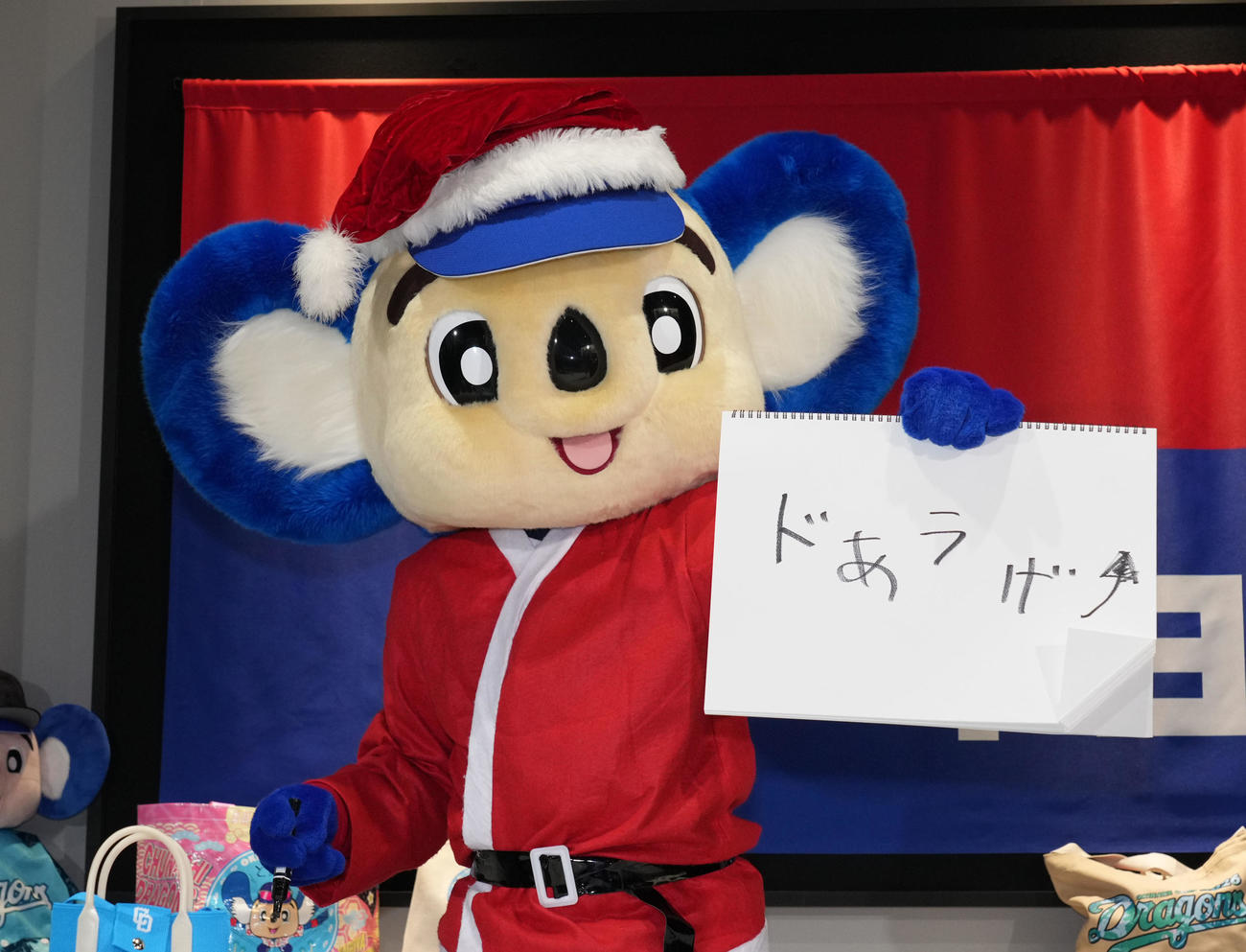 会見後、来季のチームスローガンをドアラ風に記しポーズを決めるドアラ（撮影・森本幸一）