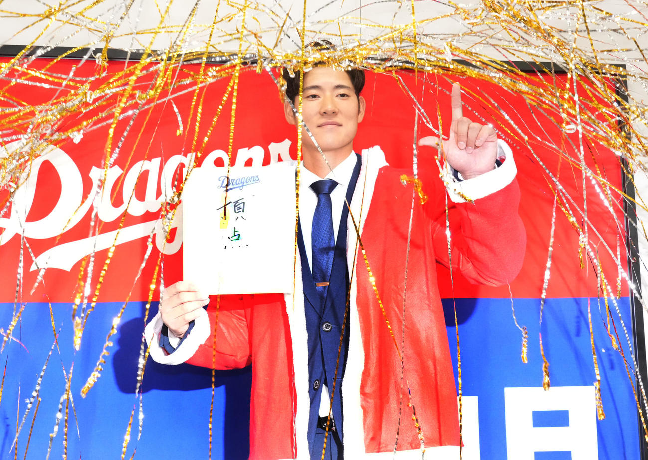 交渉を終え会見後、色紙に「頂点」と記しポーズを決める上林（撮影・森本幸一）