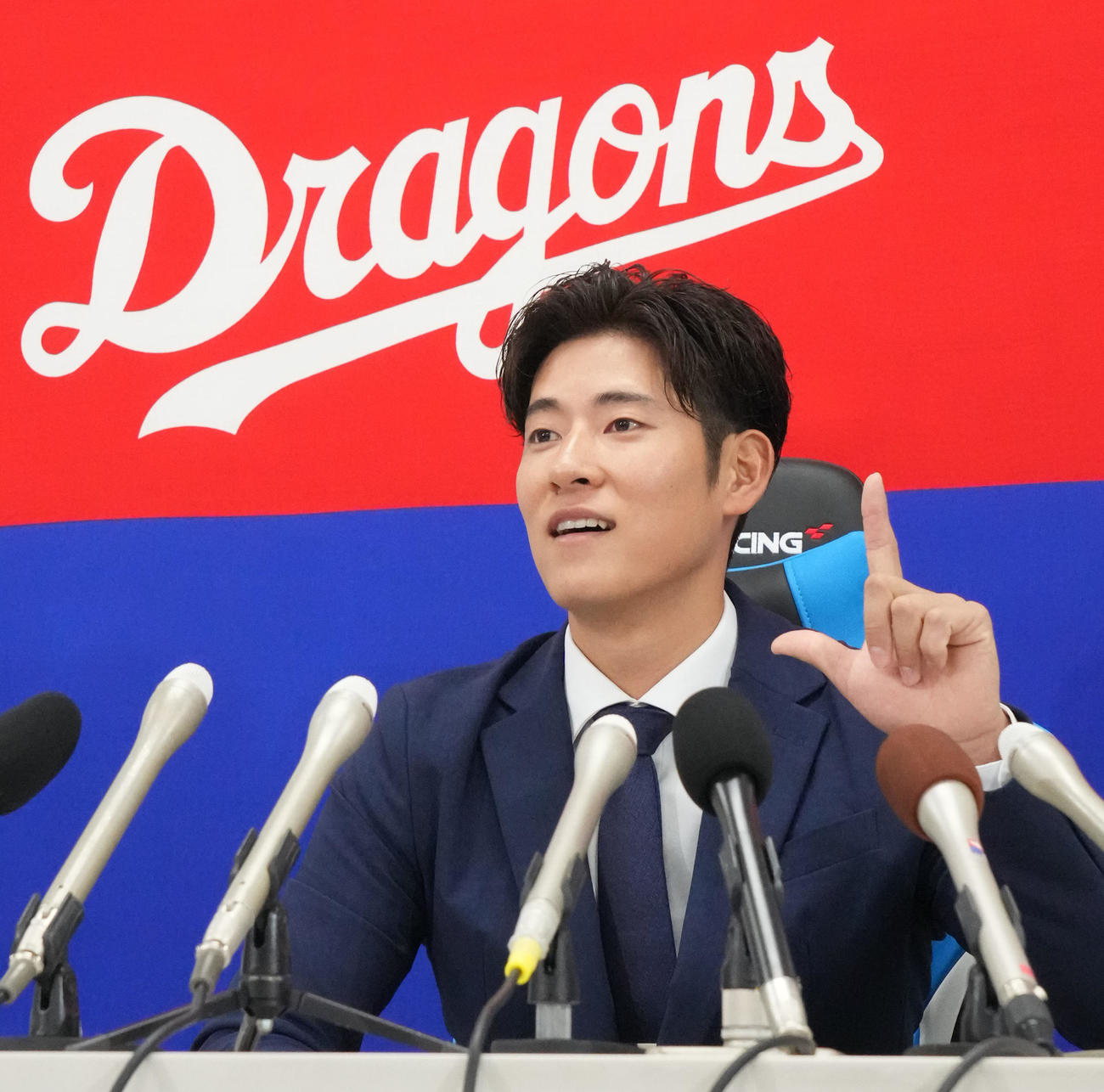 会見の席で来季本塁打を打った際のポーズ案を披露する上林（撮影・森本幸一）