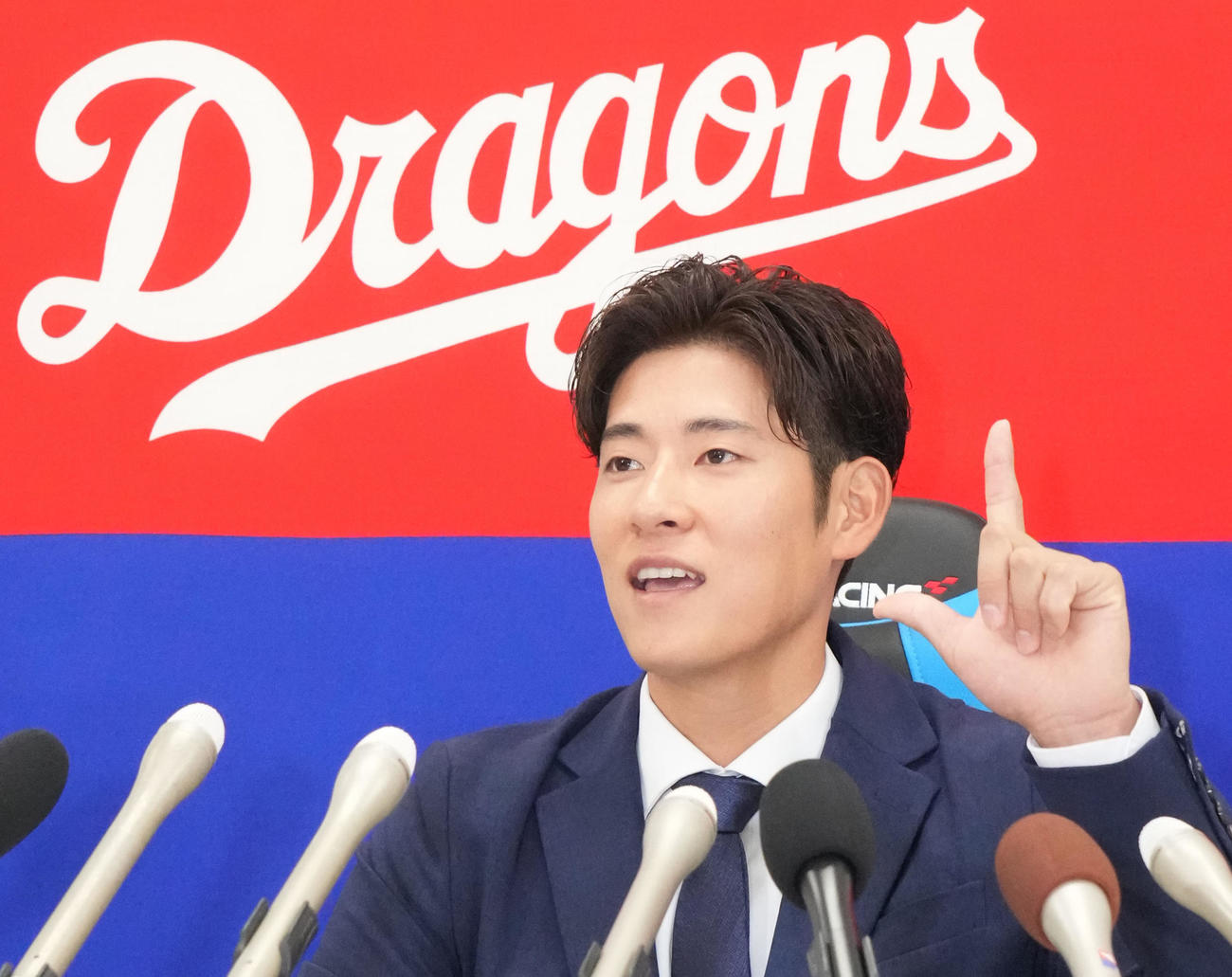 会見の席で来季本塁打を打った際のポーズ案を披露する上林（撮影・森本幸一）