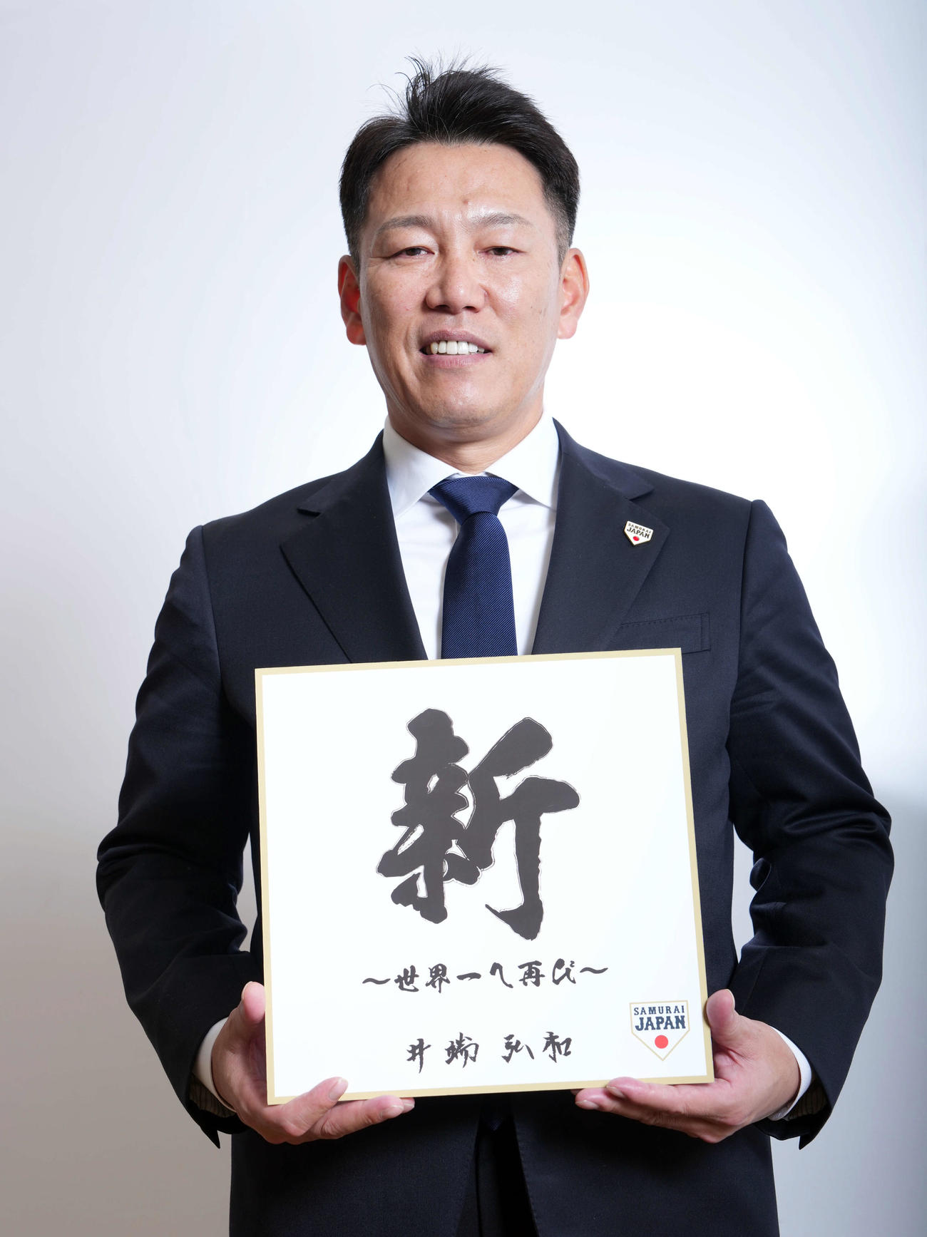 「新」の色紙を手に笑顔を見せる侍ジャパンの井端監督（撮影・たえ見朱実）