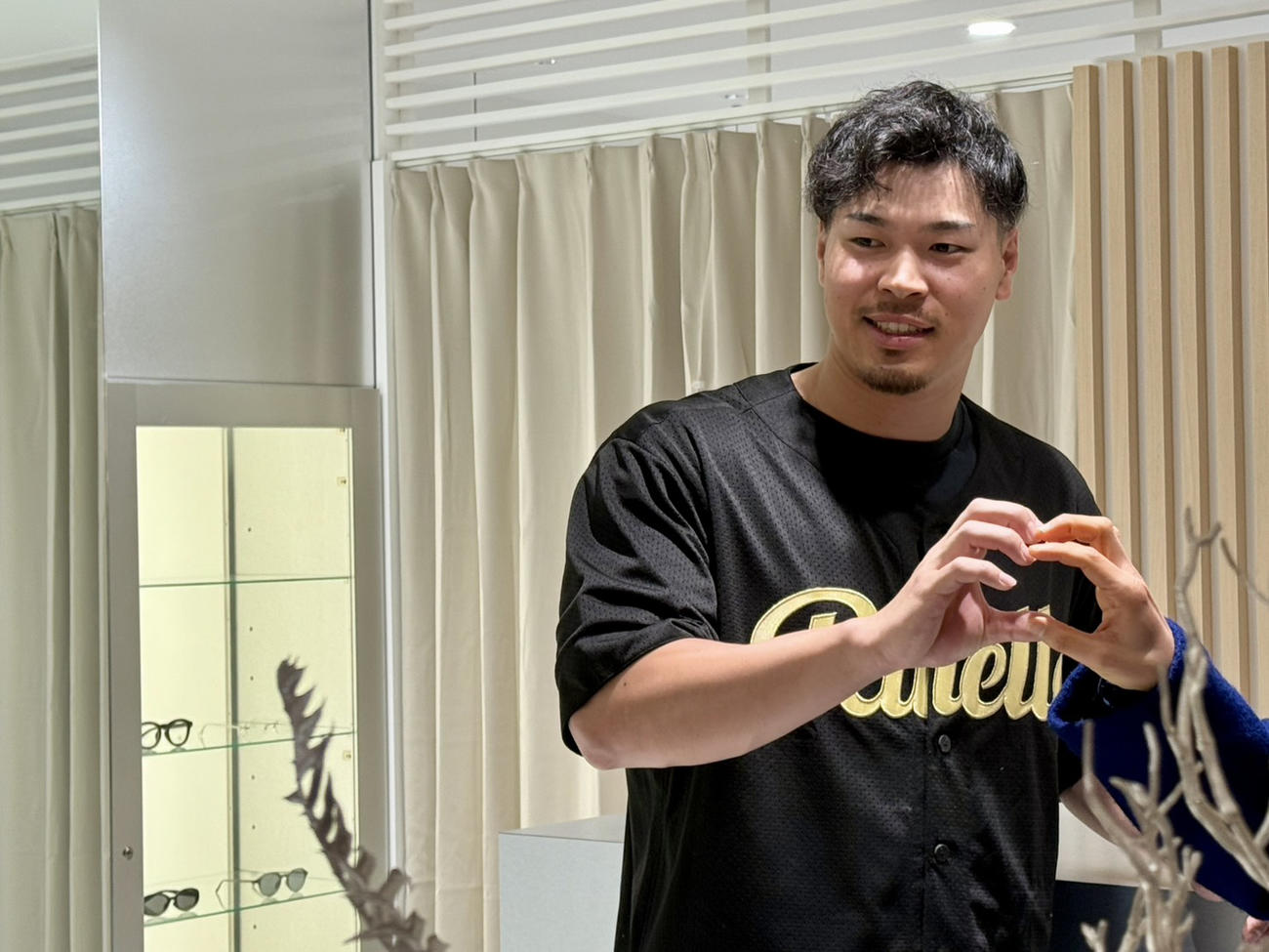 クリスマスにRUELLE大阪堀江で「1日店長を務め、イベント当選者との2ショット撮影でハートマークを作る阪神佐藤輝（撮影・中島麗）