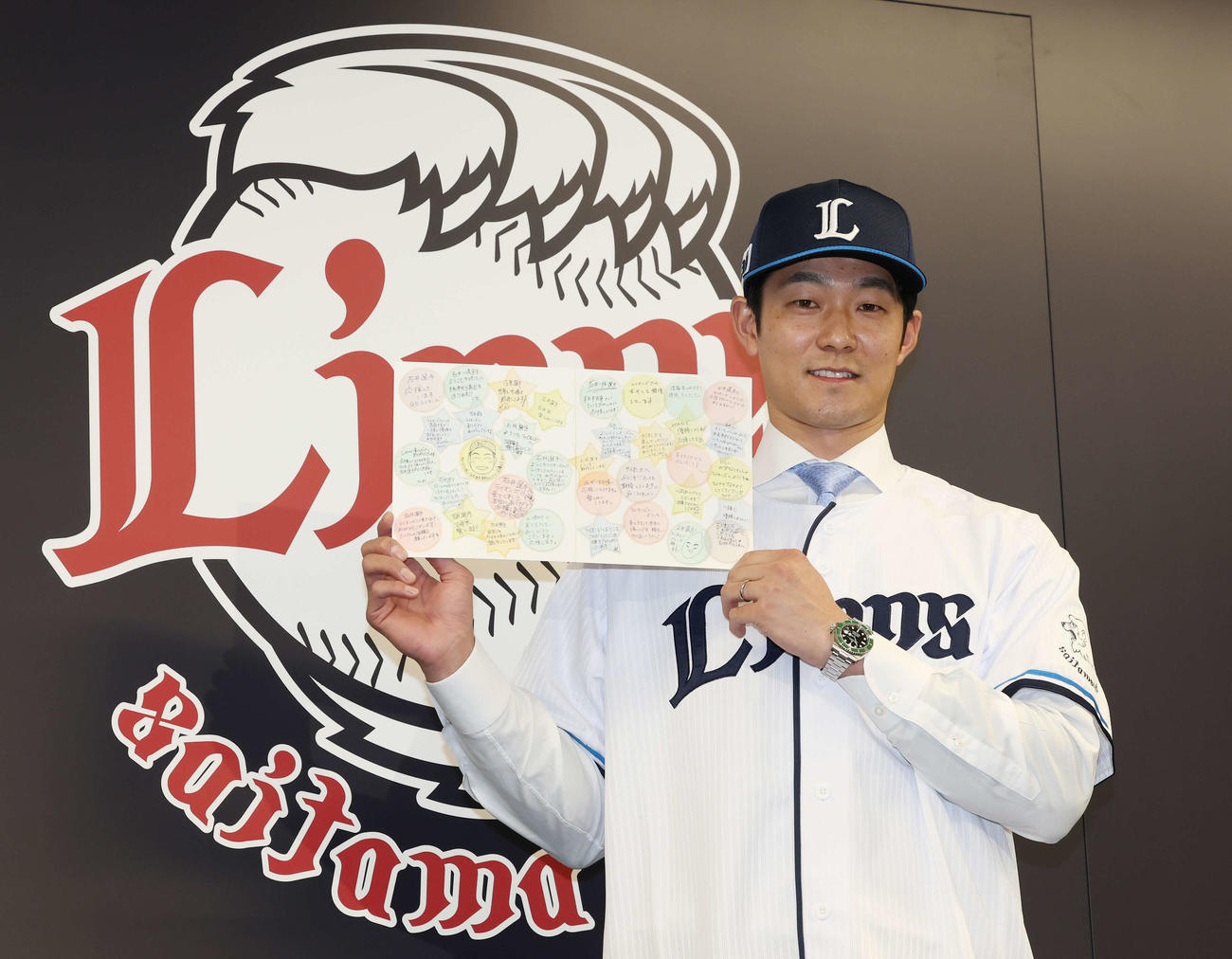 西武入団会見でファンからのメッセージを贈られ笑顔の石井（撮影・宮地輝）