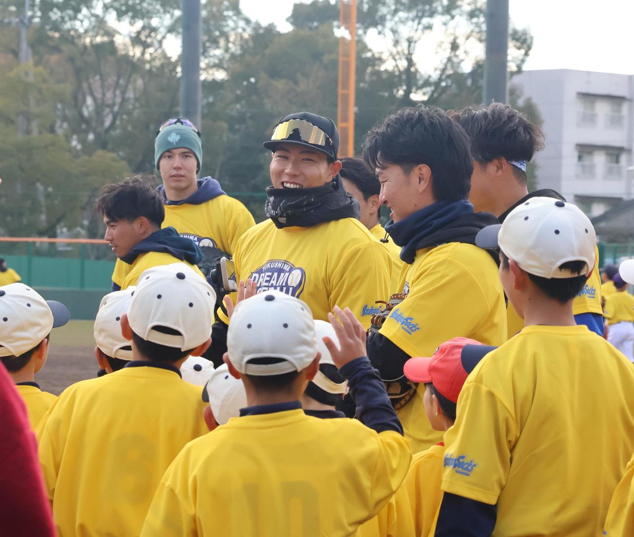 四国IL徳島OBとして「徳島ドリームベースボールプロジェクト」に参加し、野球教室で子どもたちに囲まれて笑顔を見せる阪神工藤（撮影・塚本光）