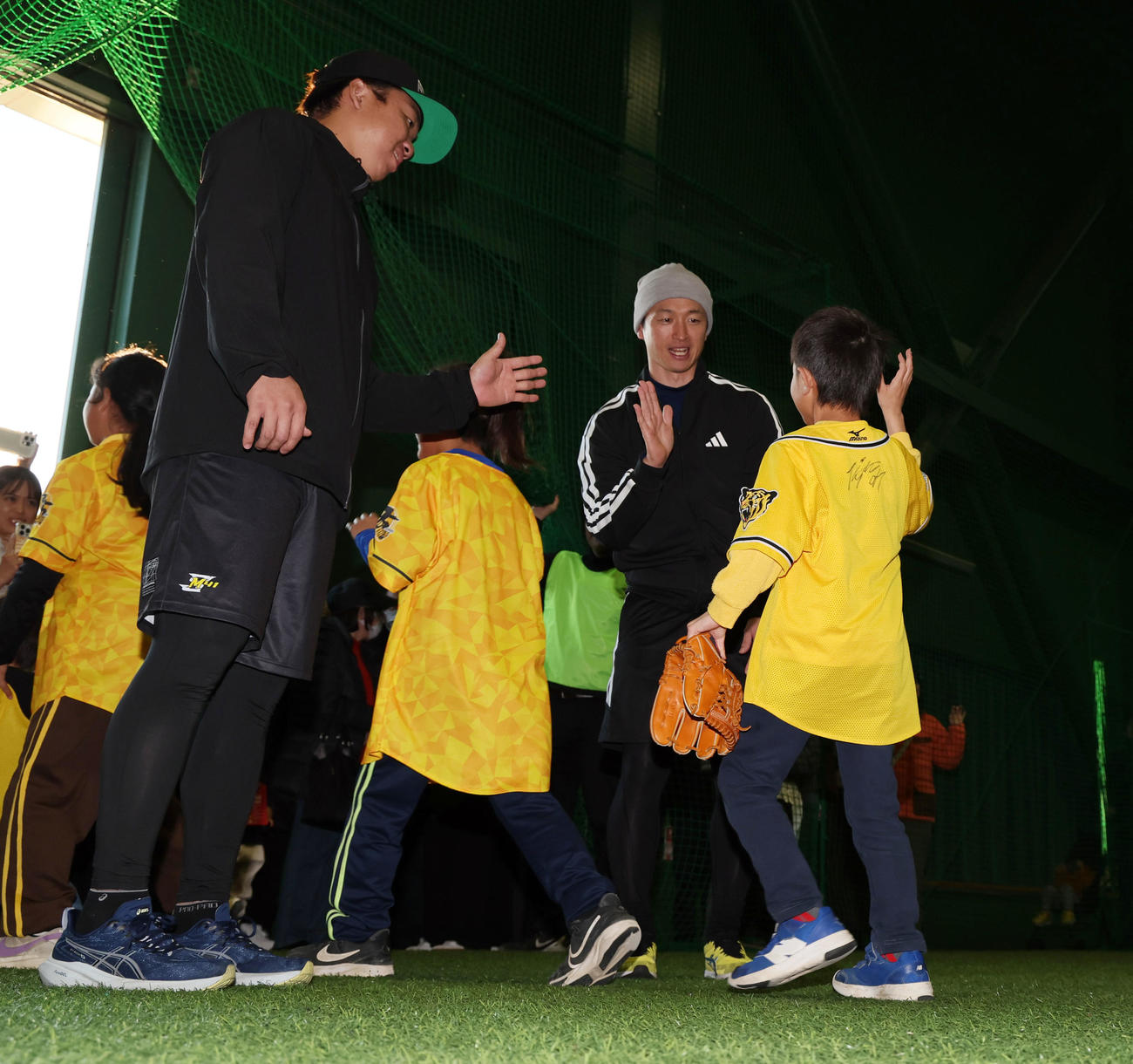 地元淡路島で自主トレを公開し引き揚げる子どもたちとハイタッチする阪神村上（左）と近本（撮影・加藤哉）