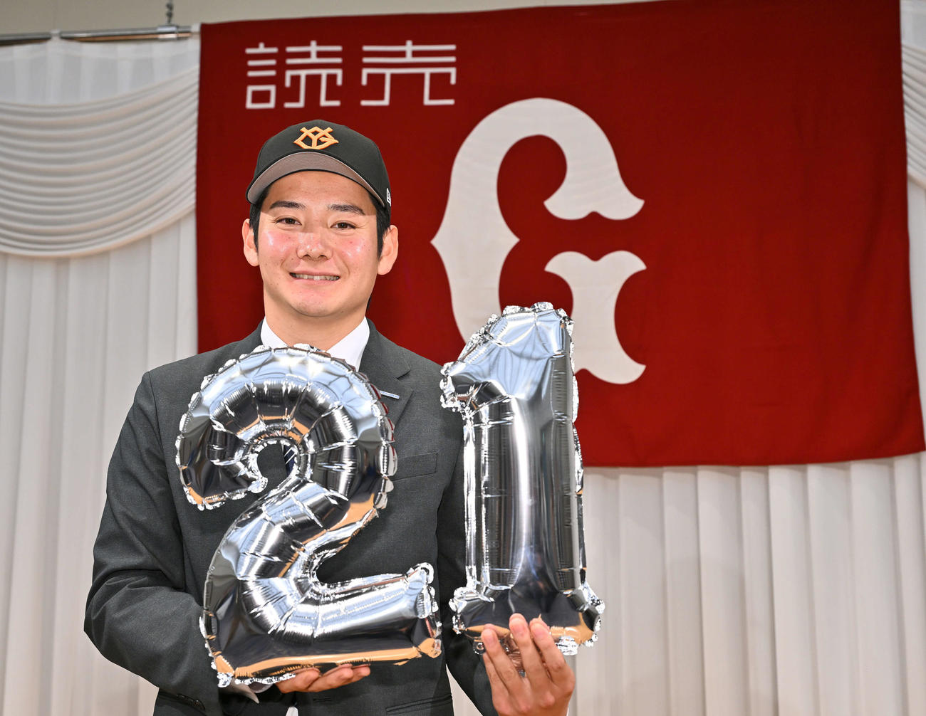 2025年11月、仮契約を終えた巨人ドラフト1位の鷺宮製作所・竹丸は、背番号「21」のバルーンを手に笑顔（撮影・滝沢徹郎）
