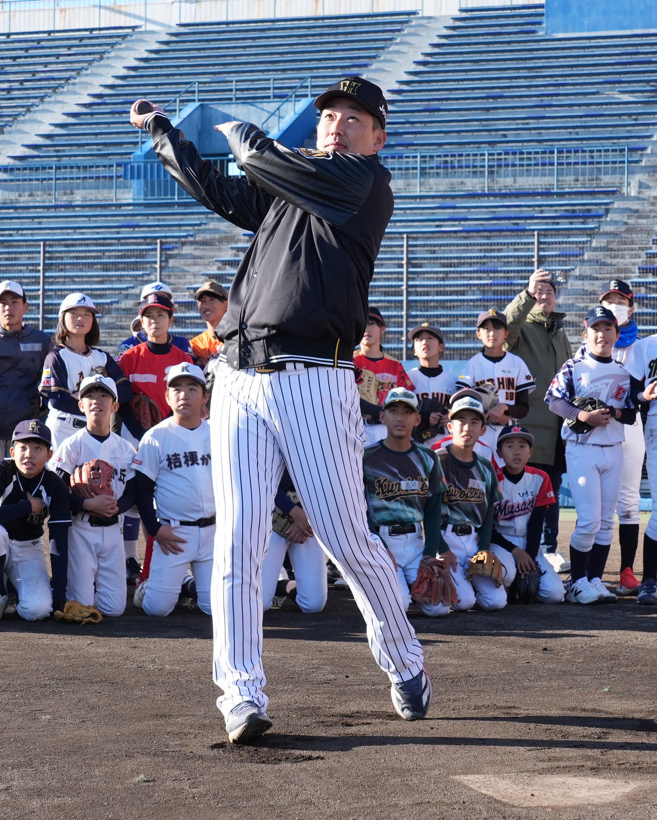 岩崎（手前）は子どもたちの前で打撃を披露する（撮影・森本幸一）