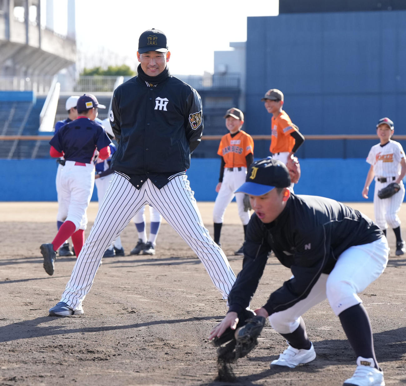 岩崎（左）は子どもたちの練習を見つめる（撮影・森本幸一）