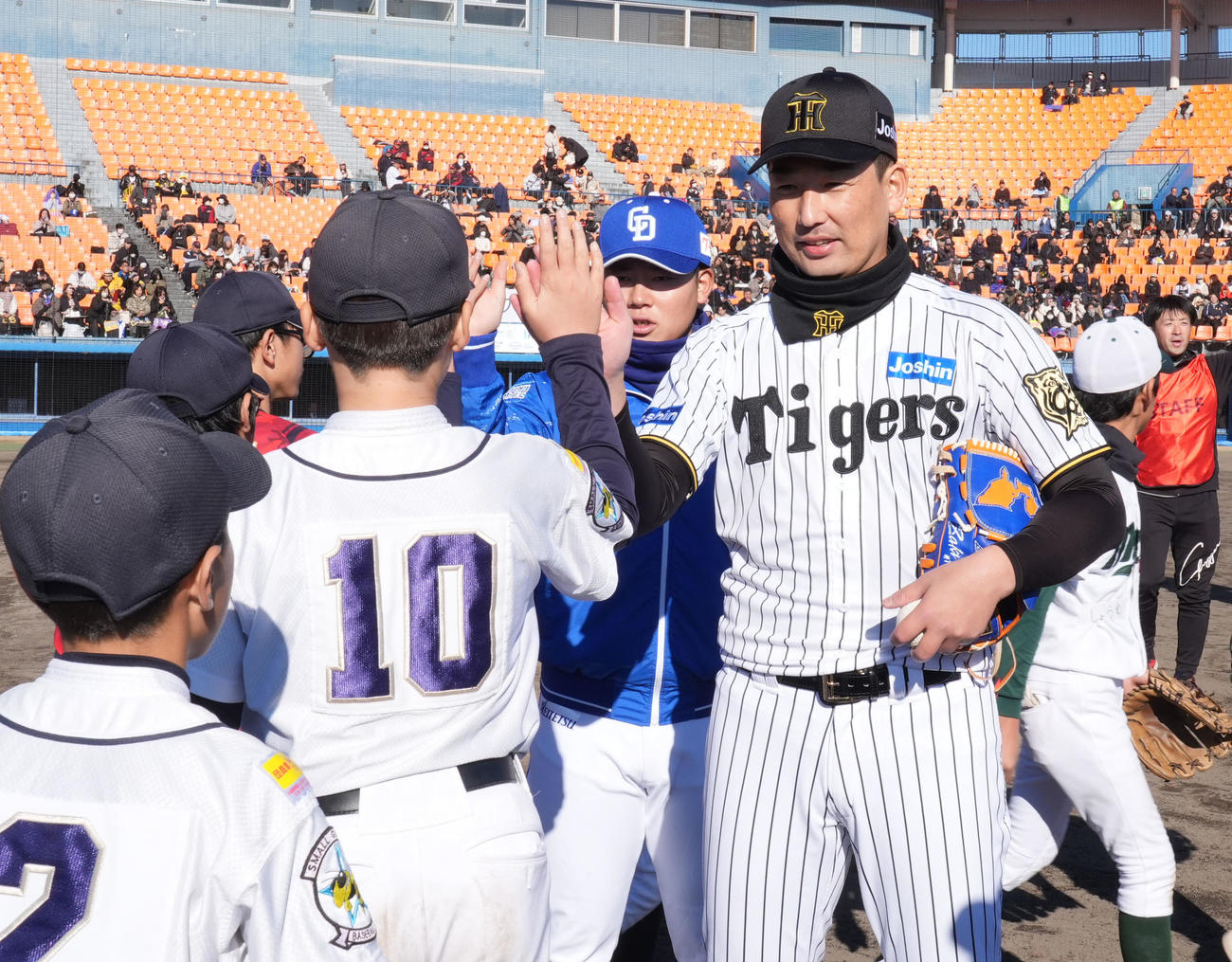 岩崎（右）は子どもたちとタッチを交わす（撮影・森本幸一）