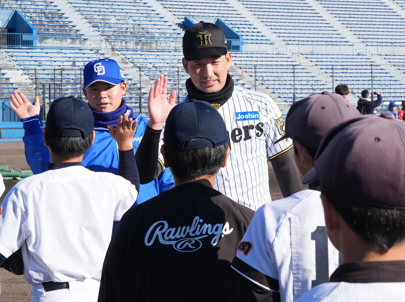 岩崎（中央）は子どもたちとタッチを交わす（撮影・森本幸一）