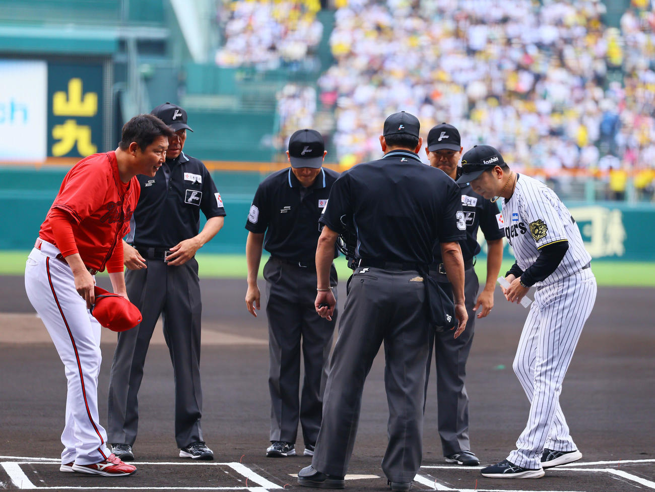 5月18日、メンバー表交換であいさつする広島新井監督（左）と阪神藤川監督