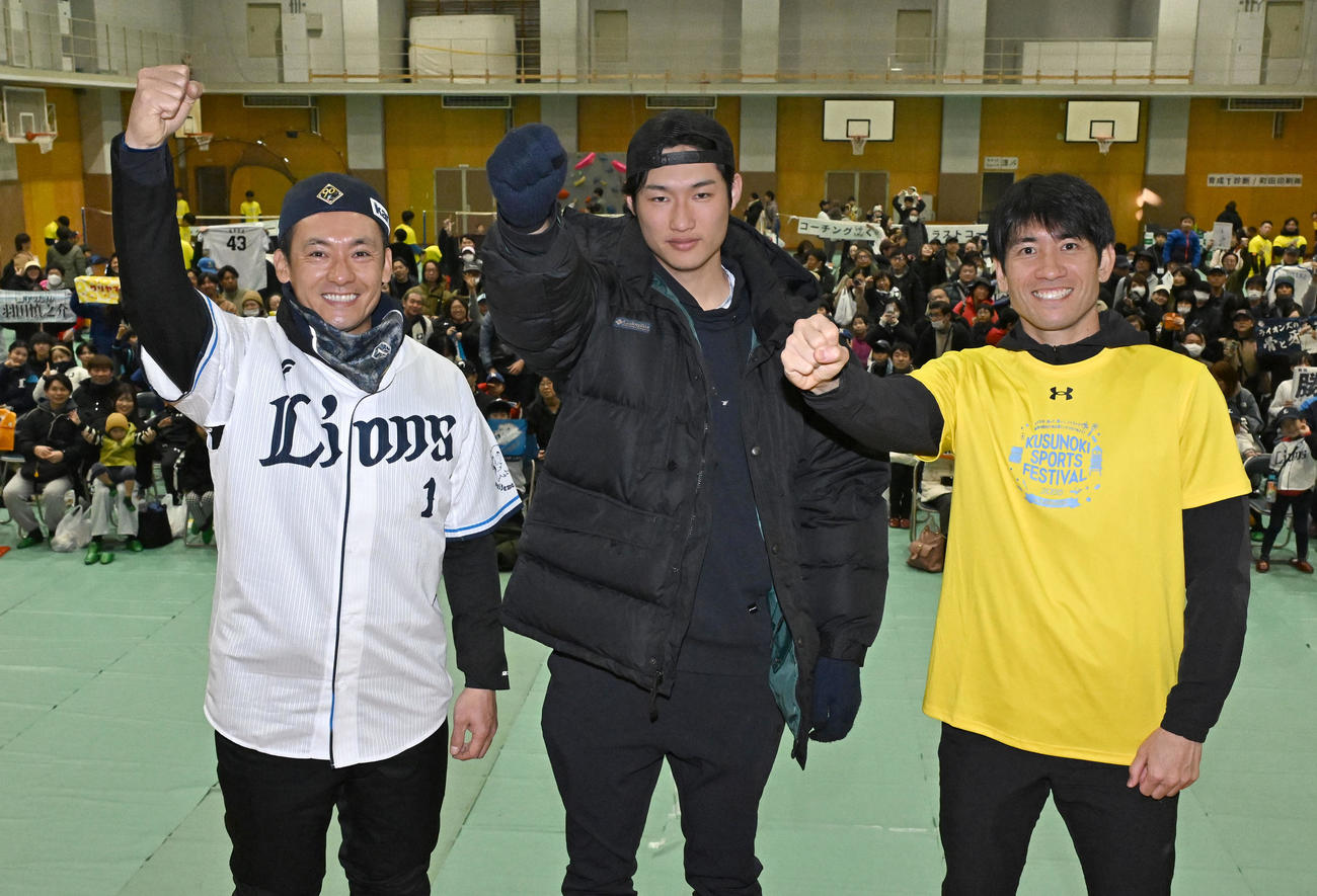 埼玉県川越市で開かれたスポーツイベントで大勢の参加者を背にポーズをとる、左から西武栗山、羽田、浦和レッズの片山（撮影・千葉一成）