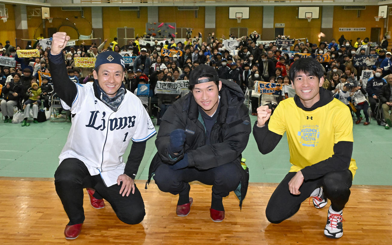 埼玉県川越市で開かれたスポーツイベントで大勢の参加者を背にポーズをとる、左から西武栗山、羽田、浦和レッズの片山（撮影・千葉一成）