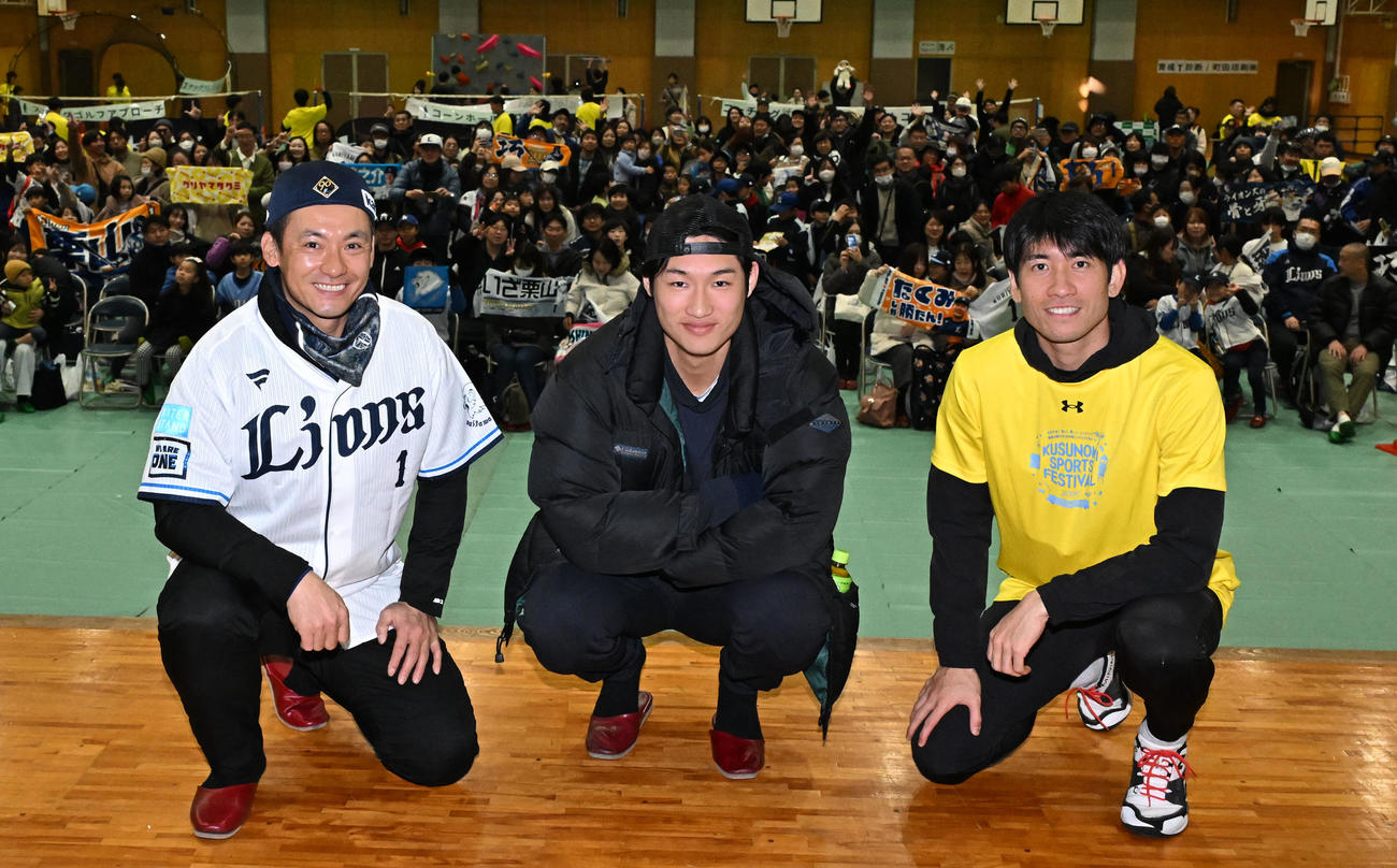 埼玉県川越市で開かれたスポーツイベントで大勢の参加者を背に記念写真に納まる、左から西武栗山、羽田、浦和レッズの片山（撮影・千葉一成）