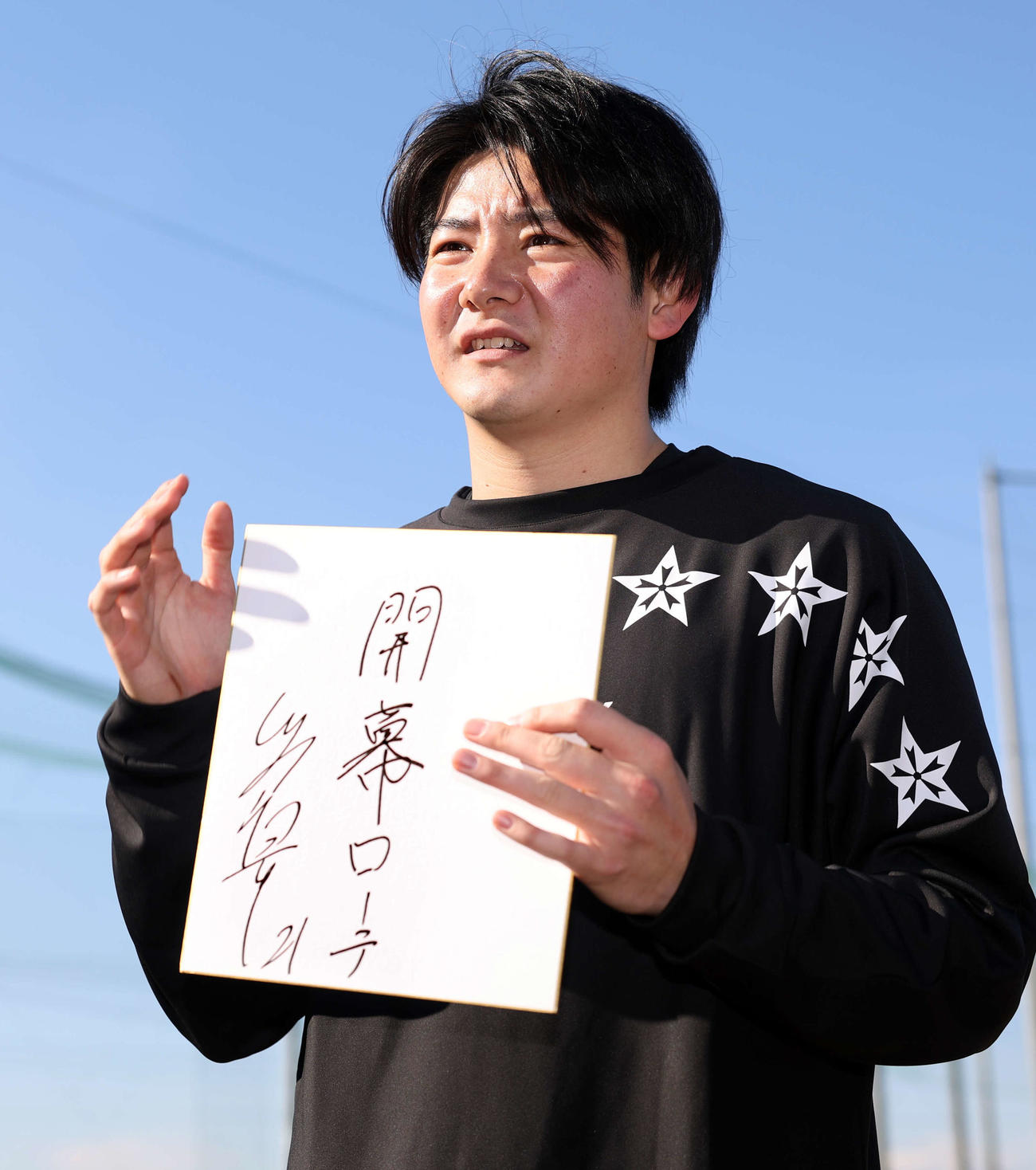 報道陣に囲まれ、色紙に「開幕ローテ」と抱負を書いた巨人竹丸（撮影・浅見桂子）