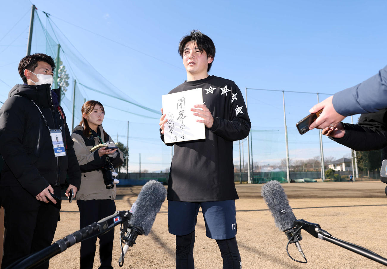 報道陣に囲まれ、色紙に「開幕ローテ」と抱負を書いた巨人竹丸（撮影・浅見桂子）