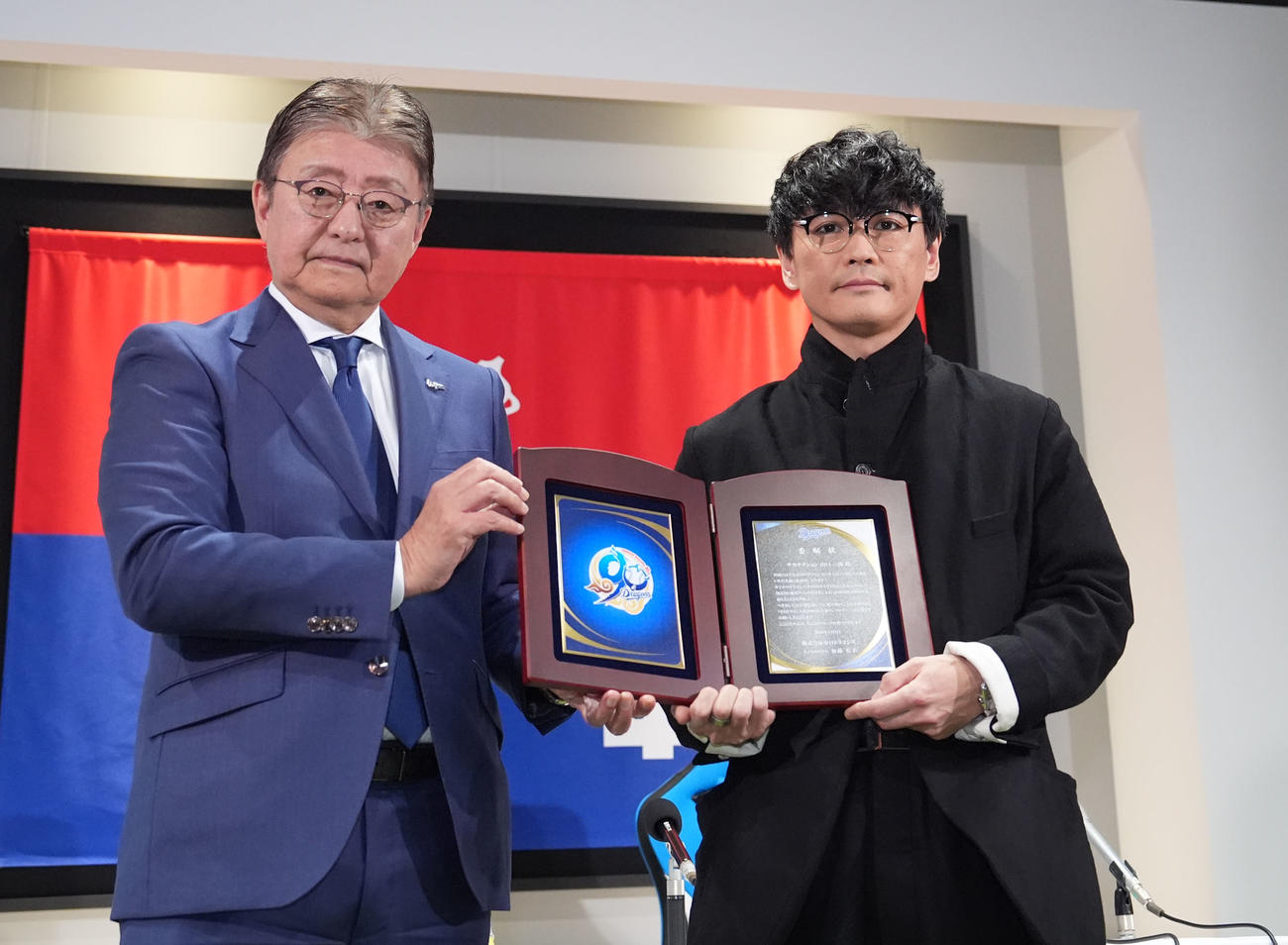 ドラゴンズ90周年広報アンバサダーに就任し加藤球団社長（左）から委任状を受け取るサカナクションの山口一郎（撮影・森本幸一）