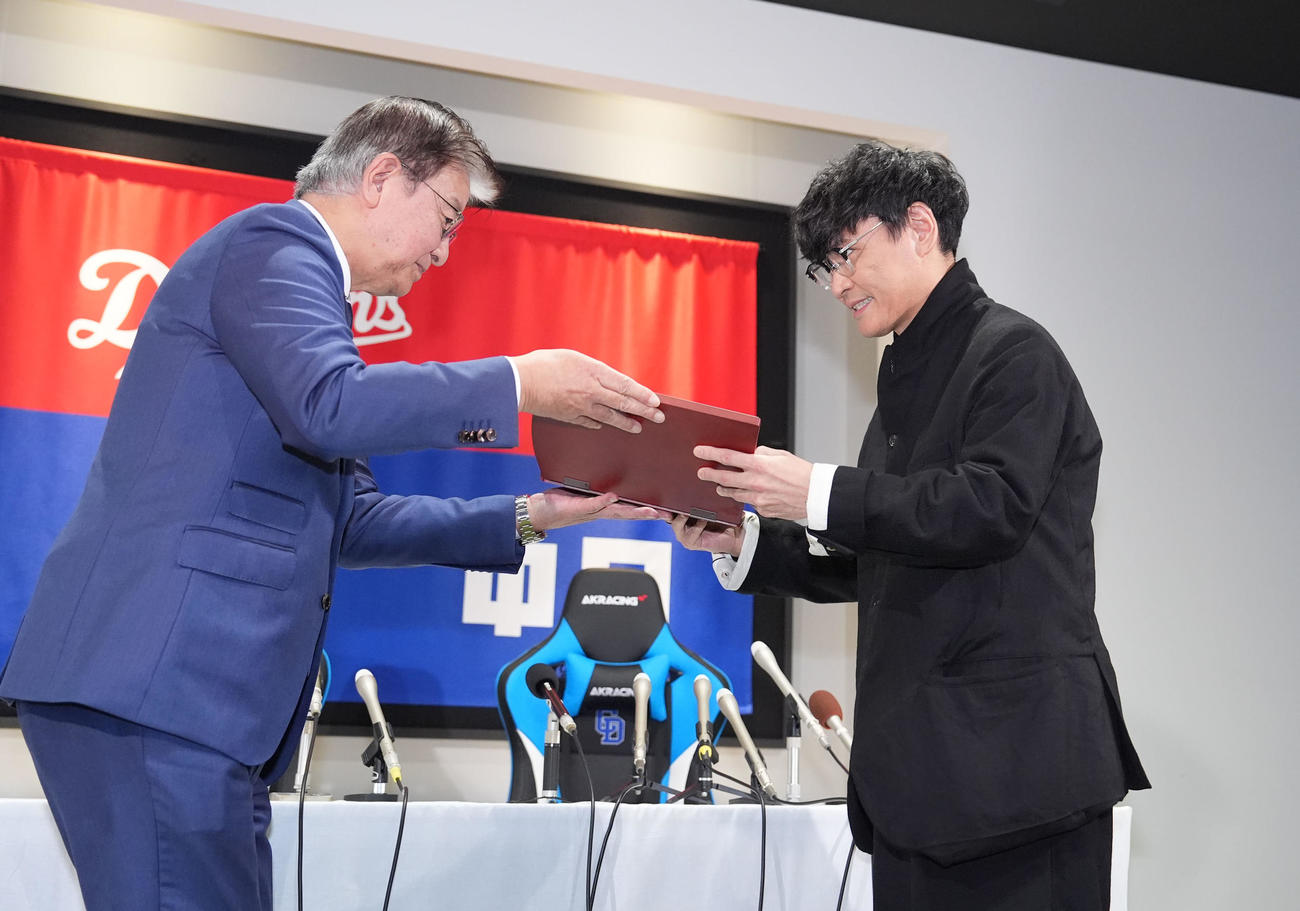 ドラゴンズ90周年広報アンバサダーに就任し加藤球団社長（左）から委任状を受け取るサカナクションの山口一郎（撮影・森本幸一）