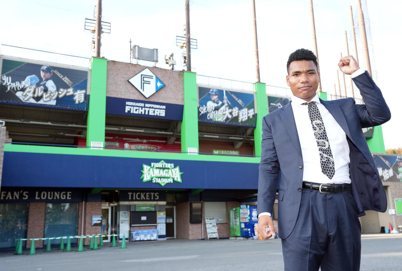 歴代のスター選手のボードを背にポーズを決める日本ハムドラフト2位のエドポロ（撮影・たえ見朱実）