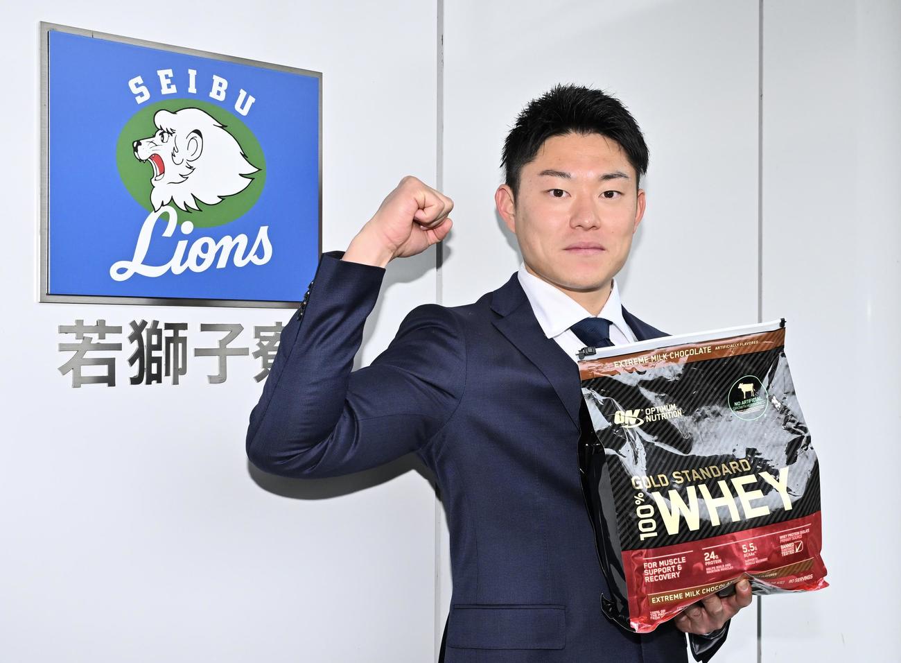 入寮した西武育成6位の上智大・正木は持ち込んだプロテインを手にポーズを決める（撮影・滝沢徹郎）