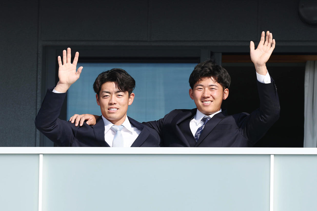 入寮し笑顔で手を振る阪神ドラフト1位の立石（右）と2位の谷端（撮影・前田充）