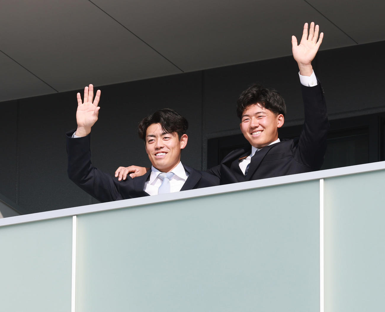 虎風荘に入寮した阪神ドラフト1位の立石（右）と2位の谷端はバルコニーで笑顔を見せる（撮影・上田博志）