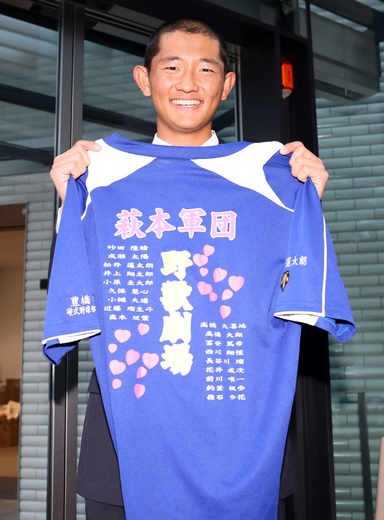 入寮した巨人育成ドラフト3位の松井蓮は母校豊橋中央の監督とチームメートから贈られたシャツを持参し笑顔（撮影・浅見桂子）