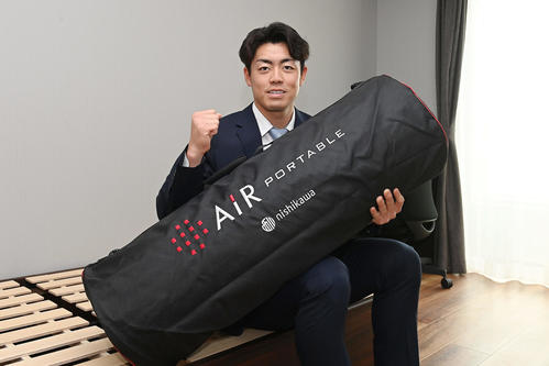 入寮で持ち込んだマットレスを手に笑顔を見せる阪神ドラフト2位の谷端