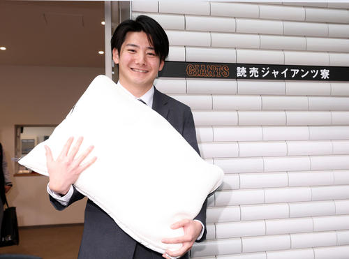 入寮した巨人ドラフト1位の竹丸は持参した枕を抱きかかえ笑顔（撮影・浅見桂子）