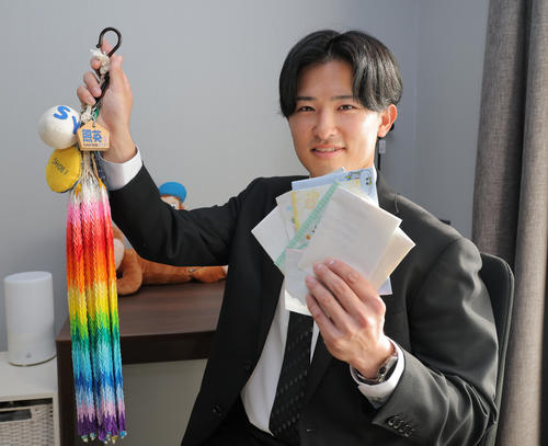 母に作ってもらったお守り（左）とファンレターを持って虎風荘に入寮する阪神育成ドラフト2位の山崎照英
